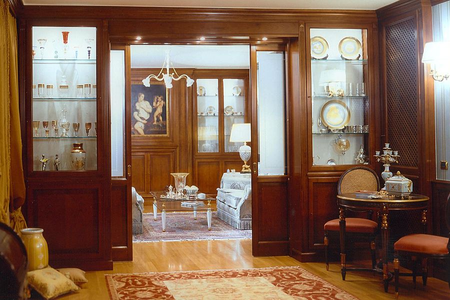 Arredare con il legno, la personalità, il calore, l’eleganza di questo materiale sempre vivo, le lavorazioni pregiate effettuate dalle mani di sapienti artigiani con finiture a campione per trasformare con pochi elementi una stanza in un ambiente di classe. Nella foto arredamento effettuato in legno di noce con cornice importante a giro su tutta la stanza, rivestimento di alcune pareti ad ospitare il caminetto, mobili e mobili libreria. Il progetto, la scelta del materiale e delle finiture conferiscono a questo ambiente una grande luminosità ed eleganza. Falegnamerie artigiane realizzano arredamenti su misura garantendone qualità di materiali, produzione ed installazione. Richiedi un preventivo, verifica i vantaggi di acquistare in falegnameria un arredamento su misura in legno progettato e realizzato solo per te, vendita diretta falegnameria cliente finale.